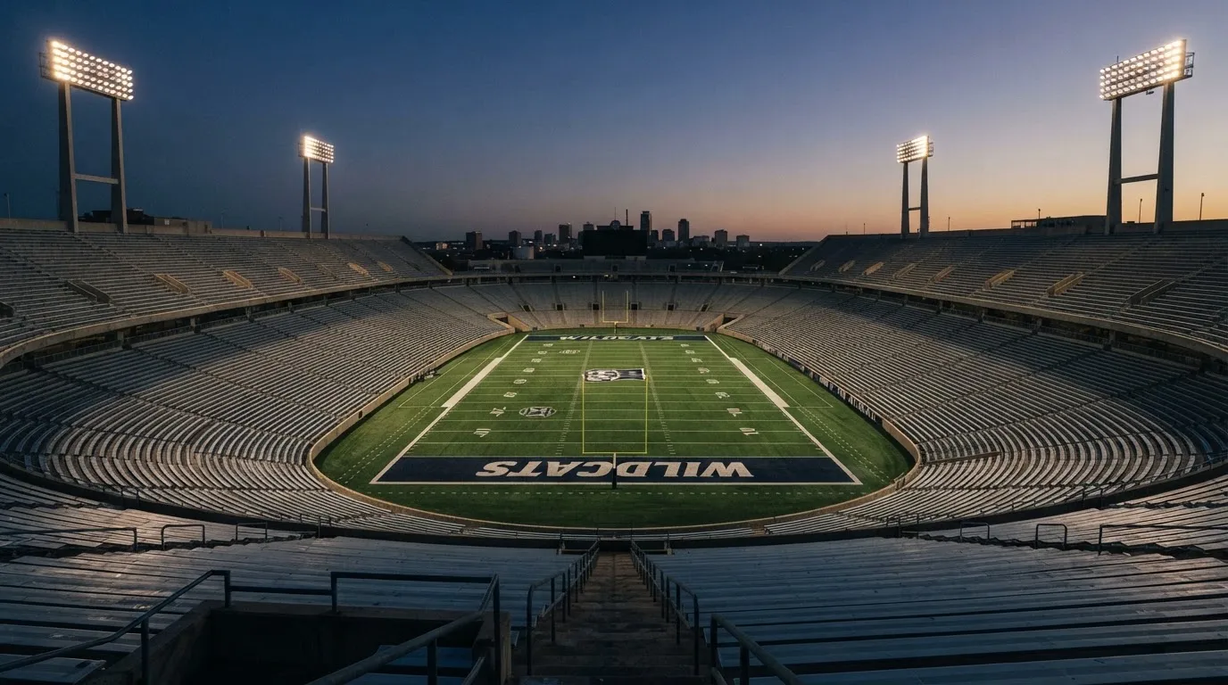 An empty football stadium with floodlight masts at dusk