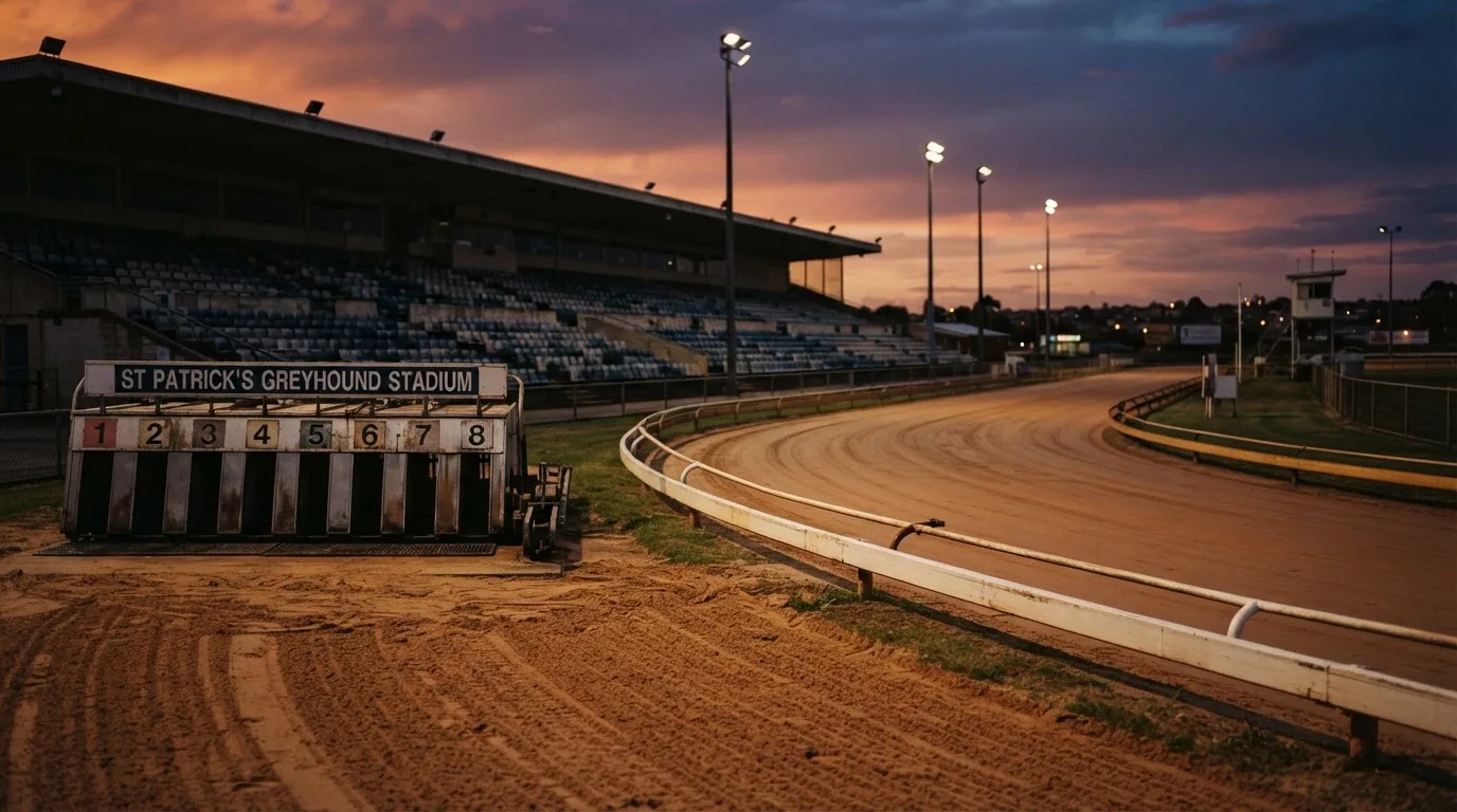 An empty football stadium with floodlight masts at dusk