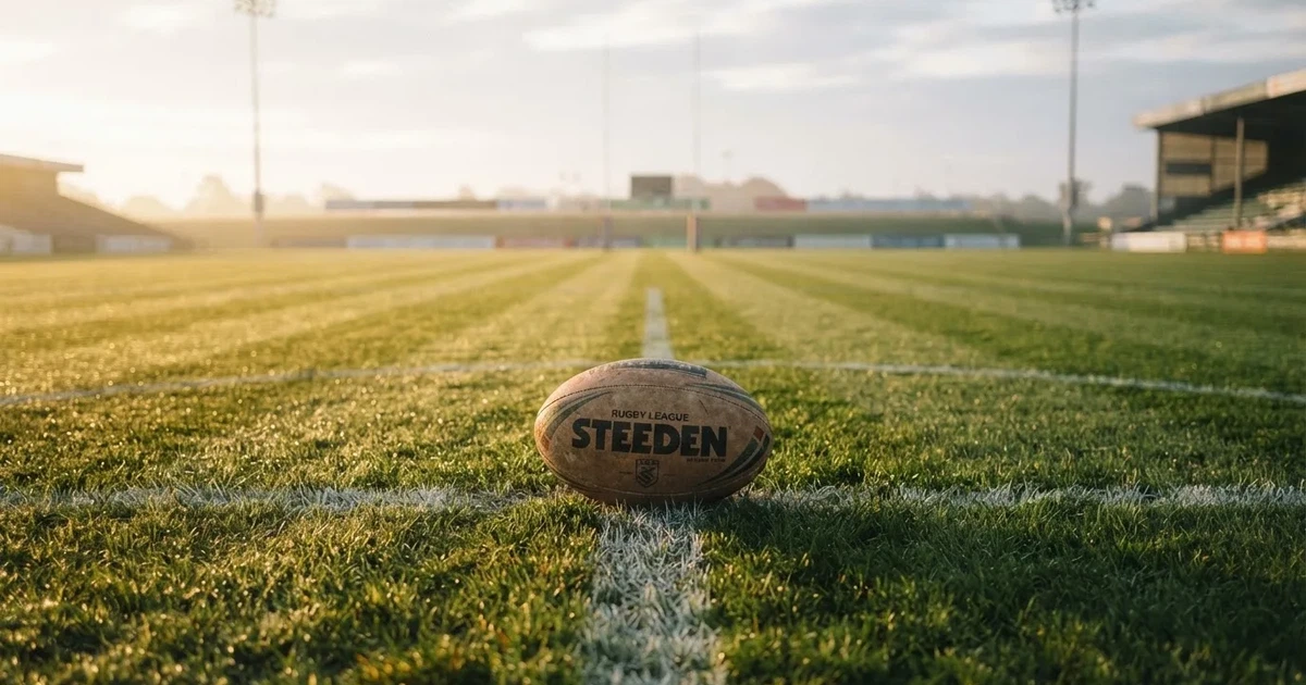 A ball on the centre spot of a grass pitch in morning light